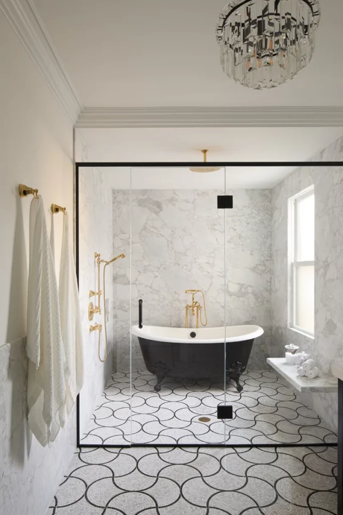 Clear glass bathroom enclosure with black hardware, a freestanding black bathtub, marble walls, and patterned tile flooring.